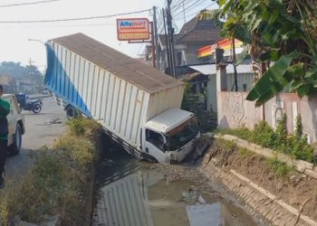 Sebuah truk yang sedang parkir di Jombang tercebur sungai usai diseruduk bus Mira