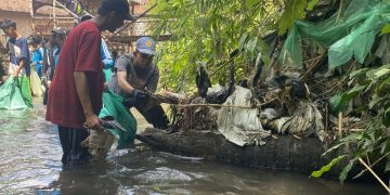 Pelajar membersihkan sungai dari sampah plastik. Foto : Bacaini.ID/Jatmiko