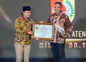 Plt Kepala Dinas Komunikasi dan Informatika Jember, Regar Jeane Dealen Nangka saat menerima penghargaan dalam Anugerah Keterbukaan Informasi Award Jawa Timur 2025.