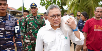 Menko Pangan Zulkifli Hasan memanggul beras di lokasi bencana. Foto: istimewa