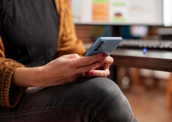 Ilustrasi seseorang menatap layar ponsel dengan ekspresi cemas, menggambarkan balasan chat dan dinamika emosional dalam hubungan