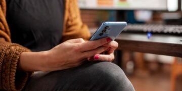 Ilustrasi seseorang menatap layar ponsel dengan ekspresi cemas, menggambarkan balasan chat dan dinamika emosional dalam hubungan