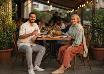 Pasangan tampil stylish dengan outfit bukber semi-formal di hotel mewah bernuansa earth tone