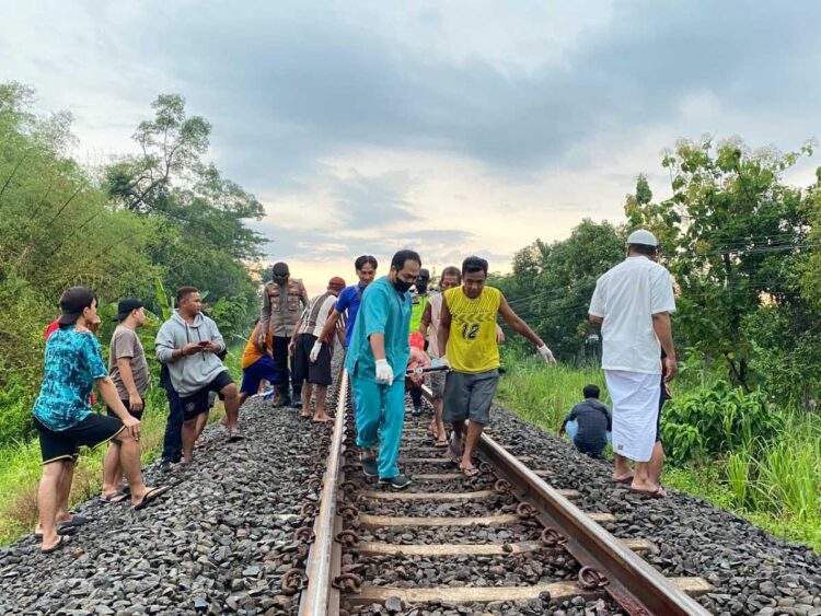 Petugas mengevakuasi potongan tubuh korban di jalur rel kereta api Desa Kepuhrejo Tulungagung