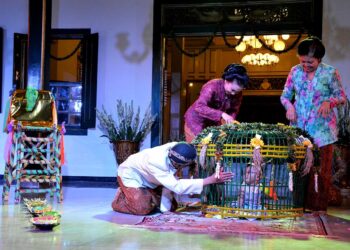 Prosesi ritual Tedak Siten dengan bayi berjalan di atas jadah tujuh warna dalam tradisi Jawa