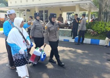 Ilustrasi calon jemaah haji Indonesia mengenakan pakaian ihram dan seragam haji saat bersiap berangkat menuju Tanah Suci di bandara