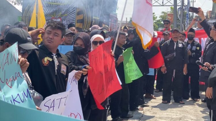 Ratusan anggota PSHT Kabupaten Blitar menggelar aksi damai di depan Kantor Bupati Blitar dengan mengenakan pakaian hitam dan membawa poster tuntutan