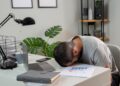 Pria kantoran terlihat lelah dan mengantuk saat bekerja di sore hari karena afternoon slump